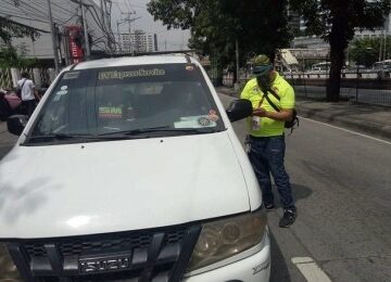 Traffic enforcer interacting with a white vehicle.