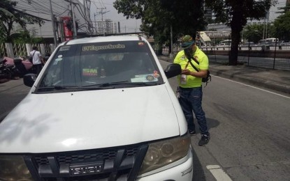 Traffic enforcer interacting with a white vehicle.